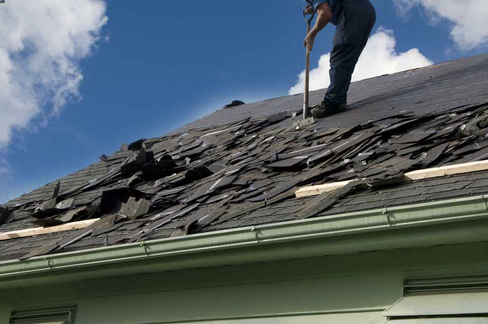 Contractor performing roof replacement on a residential home